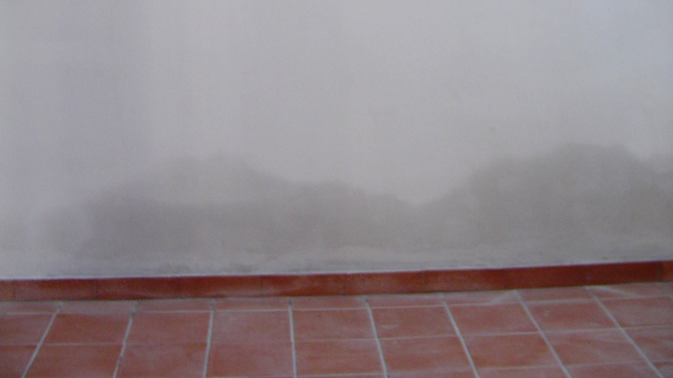 Chiazza definita di umidità alla base del muro.